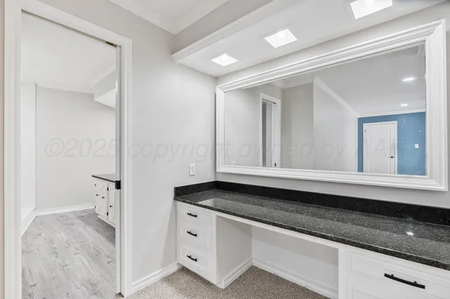 a bathroom with a granite countertop double vanity sink and a mirror