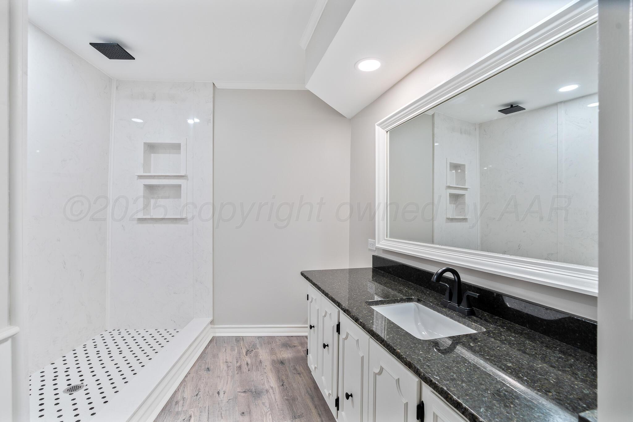 207 Yucca Terrace Plainview, TX 79072 - Photo 24 of 50 a bathroom with a granite countertop double vanity sink and a mirror