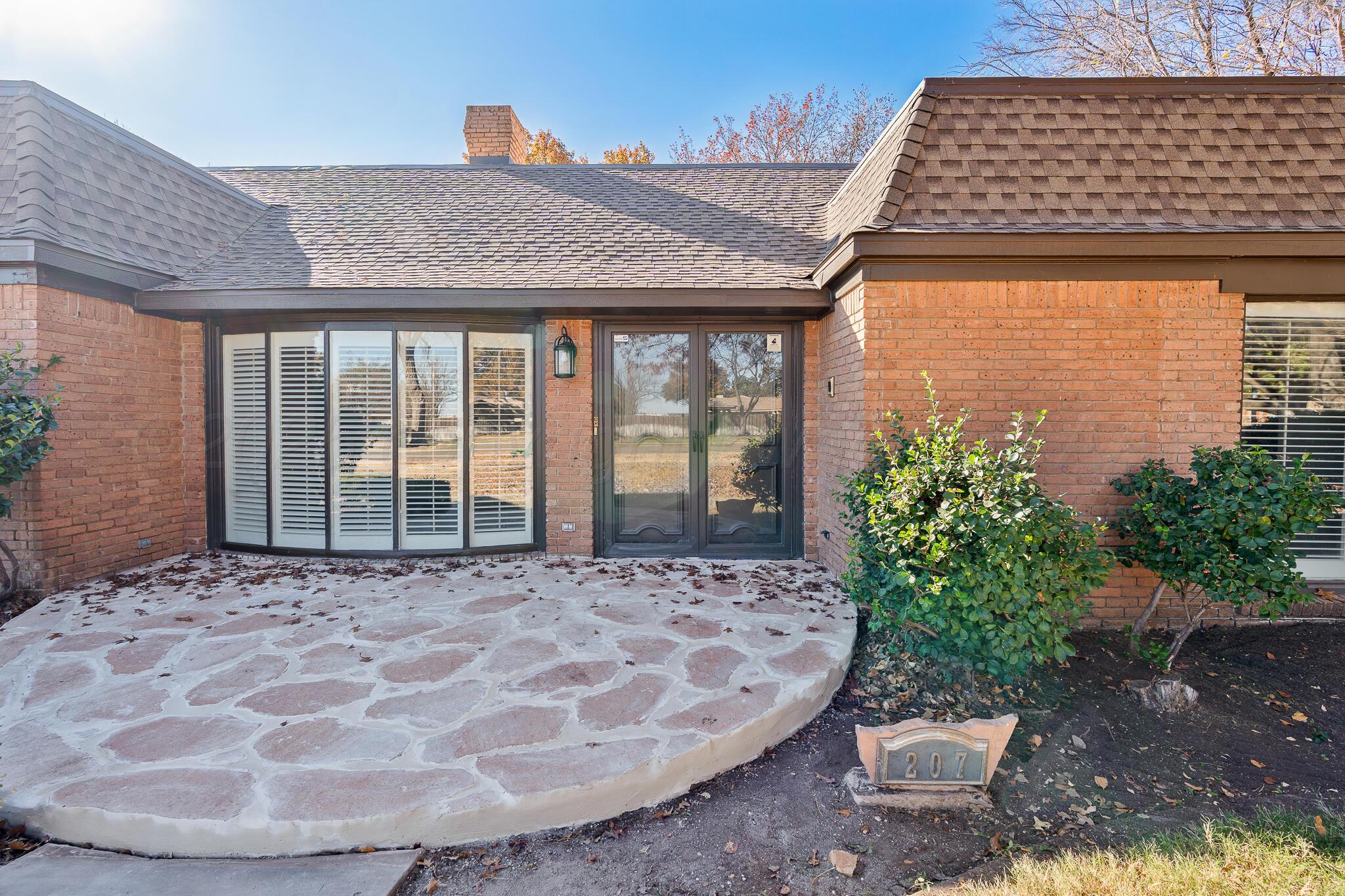 207 Yucca Terrace Plainview, TX 79072 - Photo 3 of 50 a view of a brick house with potted plants
