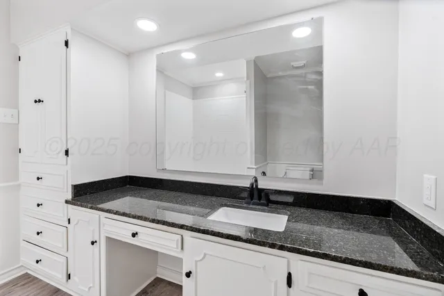 a bathroom with a granite countertop sink