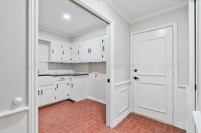 a kitchen with white cabinets and sink