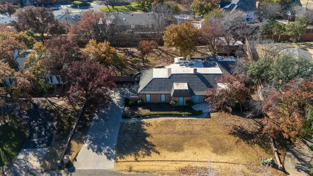 an aerial view of a house with a yard and lake view