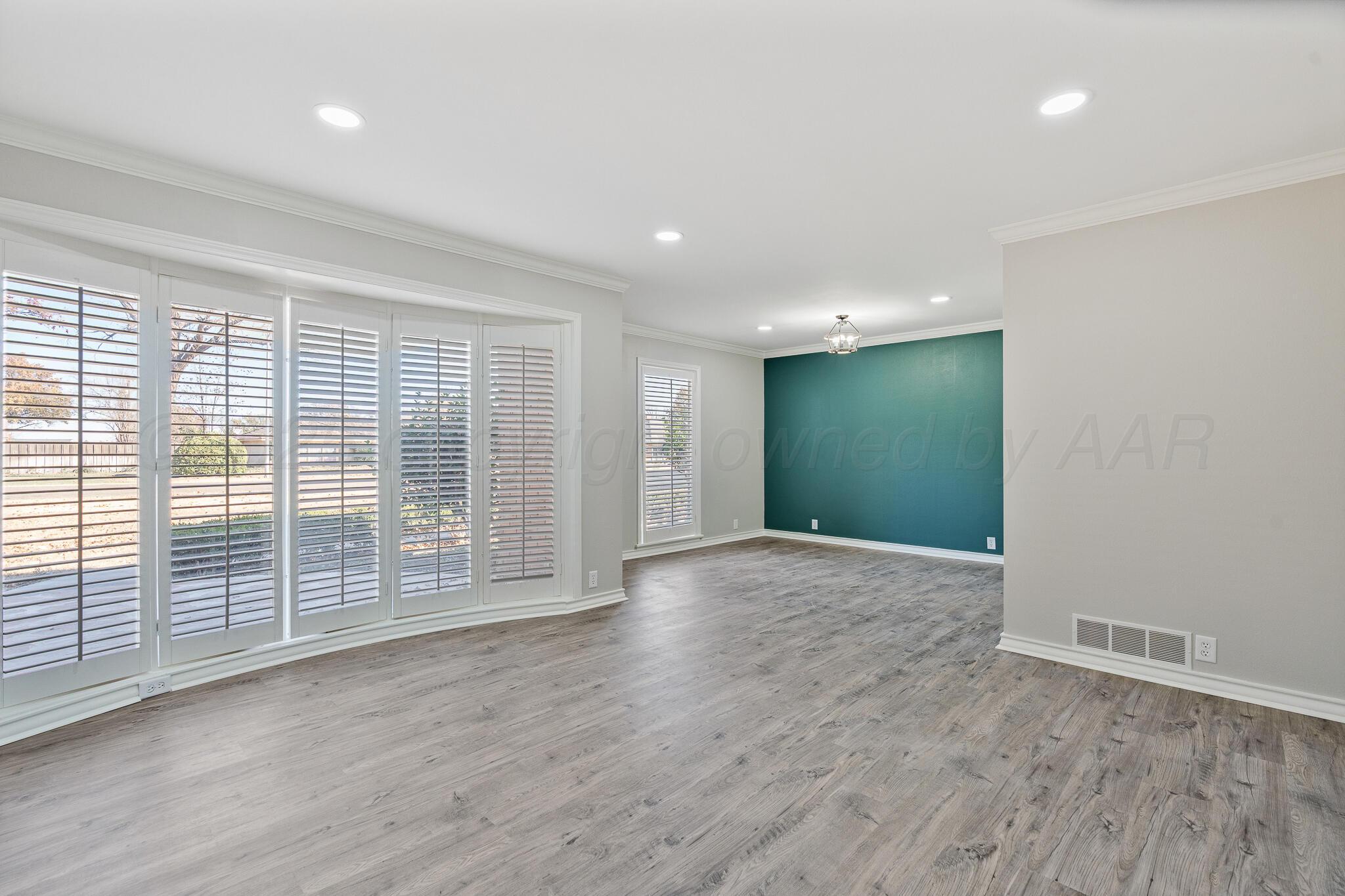 207 Yucca Terrace Plainview, TX 79072 - Photo 7 of 50 an empty room with wooden floor and windows