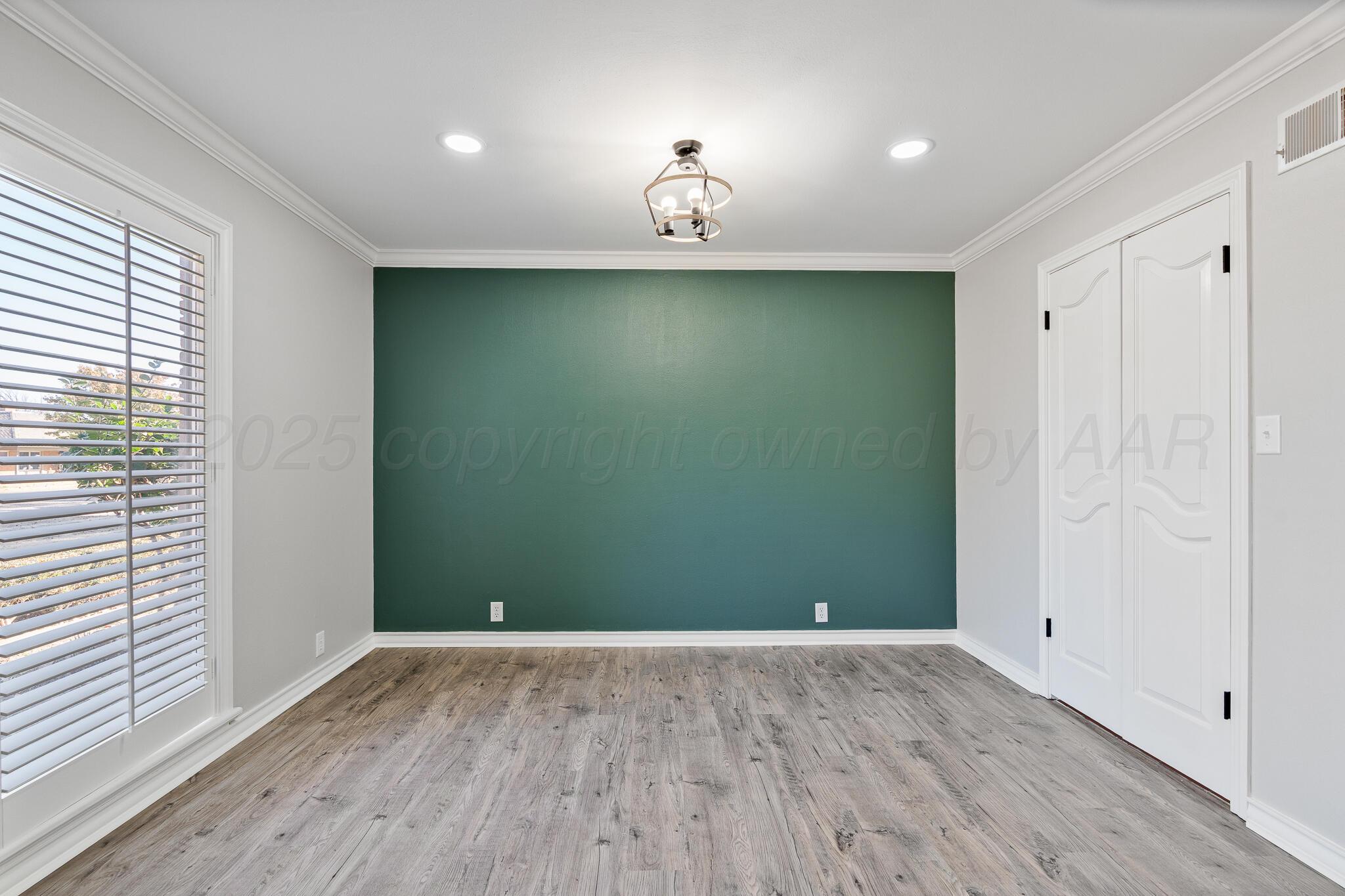 207 Yucca Terrace Plainview, TX 79072 - Photo 8 of 50 wooden floor in an empty room with a window