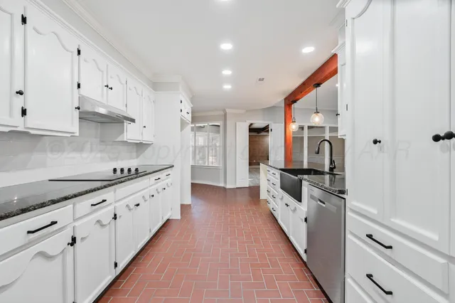 a large kitchen with stainless steel appliances granite countertop a lot of counter space and wooden floors