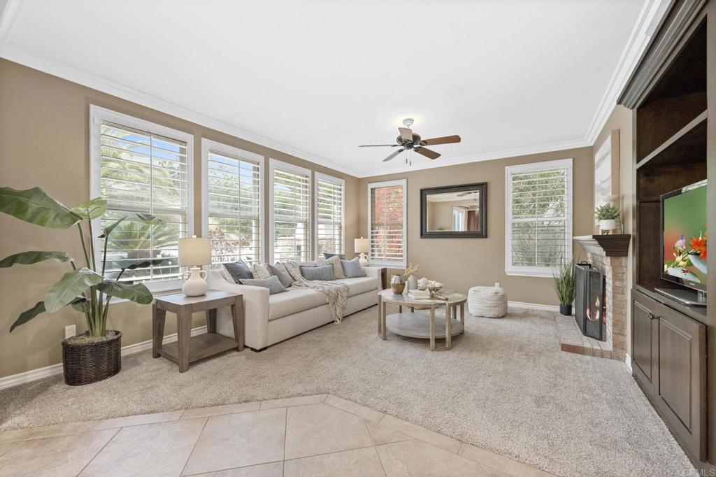 8021 Paseo Arrayan Carlsbad, CA 92009 - Photo 19 of 68 a living room with furniture a flat screen tv and large windows