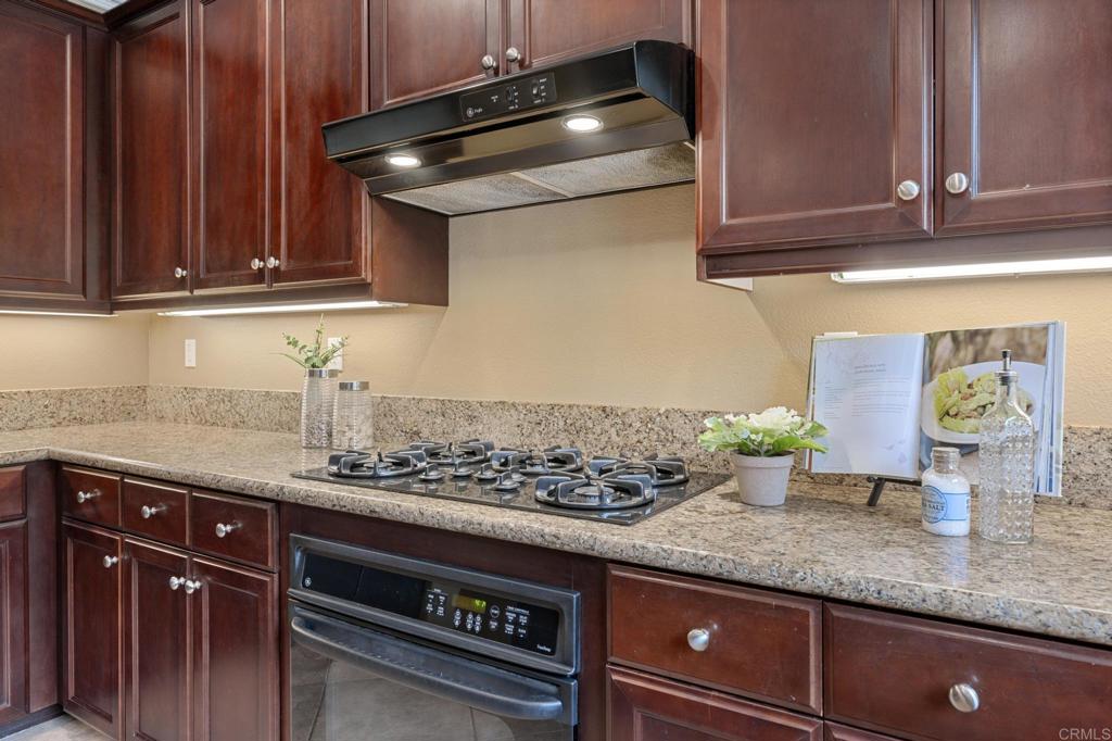 8021 Paseo Arrayan Carlsbad, CA 92009 - Photo 27 of 68 a kitchen with stainless steel appliances granite countertop a sink stove and cabinets