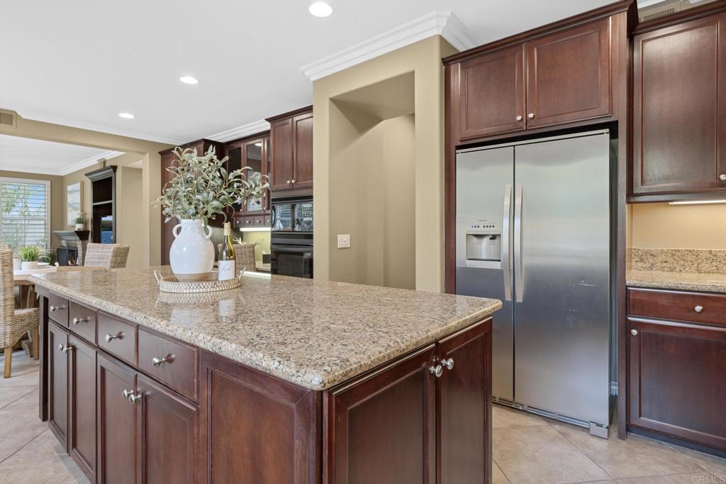 8021 Paseo Arrayan Carlsbad, CA 92009 - Photo 28 of 68 a kitchen with stainless steel appliances granite countertop a refrigerator and wooden cabinets