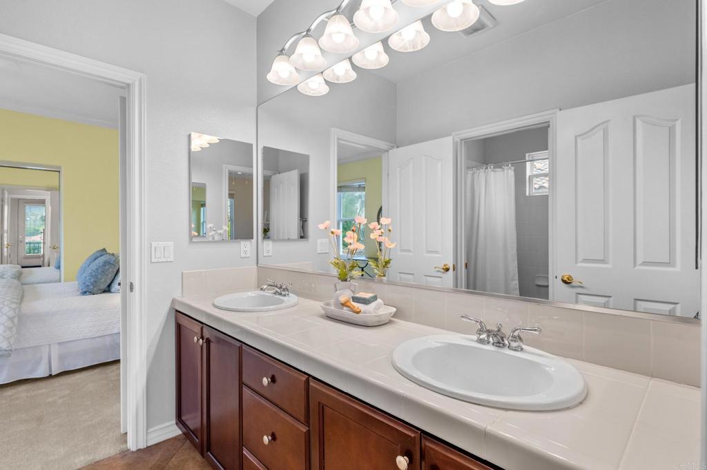 8021 Paseo Arrayan Carlsbad, CA 92009 - Photo 46 of 68 a bathroom with double vanity sinks a vanity a lamp and a mirror