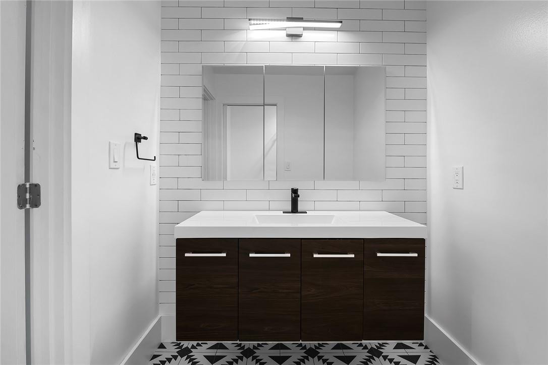 9085 Southwest 20th Street, Unit D Boca Raton, FL 33428 - Photo 13 of 25 a bathroom with a sink and a mirror