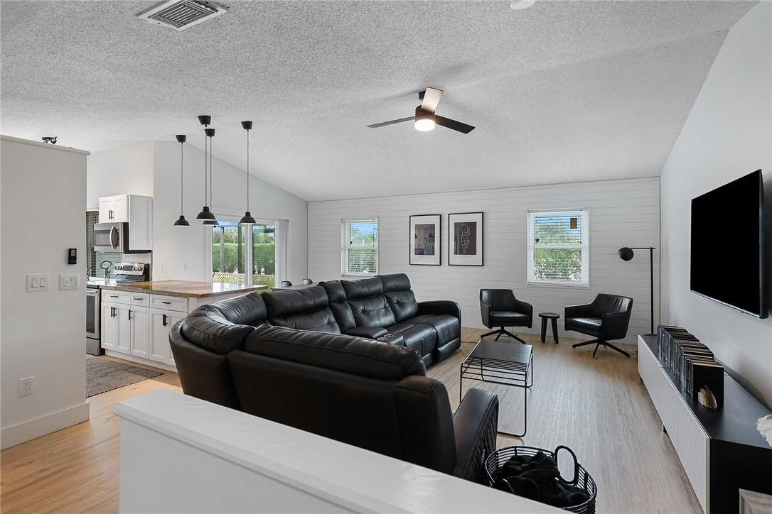 9085 Southwest 20th Street, Unit D Boca Raton, FL 33428 - Photo 3 of 25 a living room with furniture a flat screen tv and a window