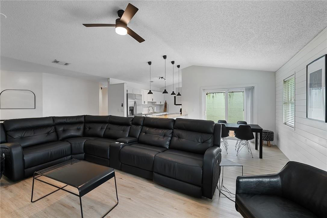 9085 Southwest 20th Street, Unit D Boca Raton, FL 33428 - Photo 5 of 25 a living room with furniture and a chandelier