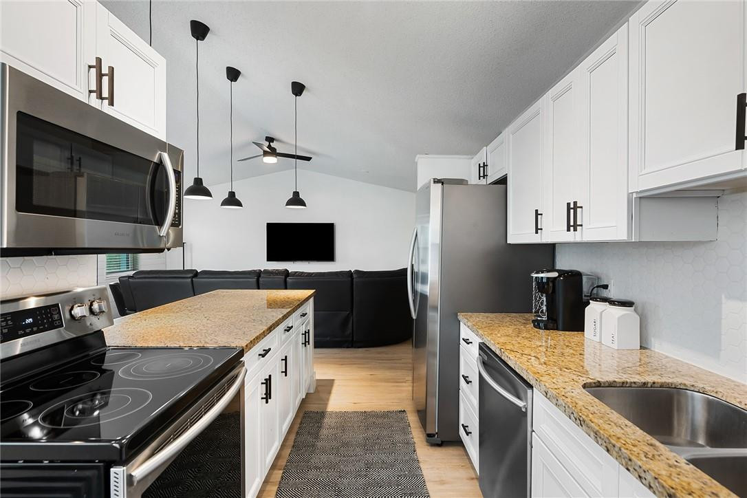 9085 Southwest 20th Street, Unit D Boca Raton, FL 33428 - Photo 7 of 25 a kitchen with a sink stove and microwave