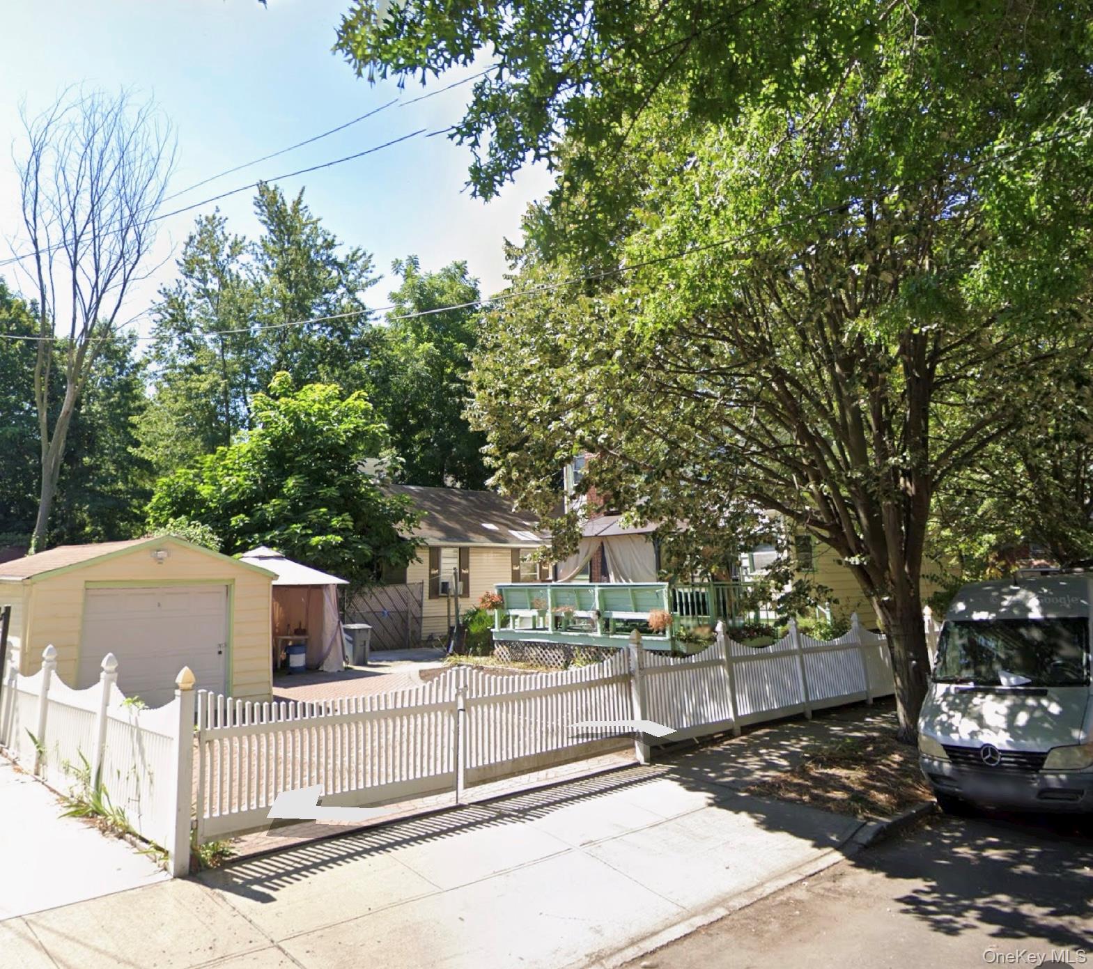 46-27 206th Street Queens, NY 11361 - Photo 2 of 2 a view of city street with a building and trees in the background