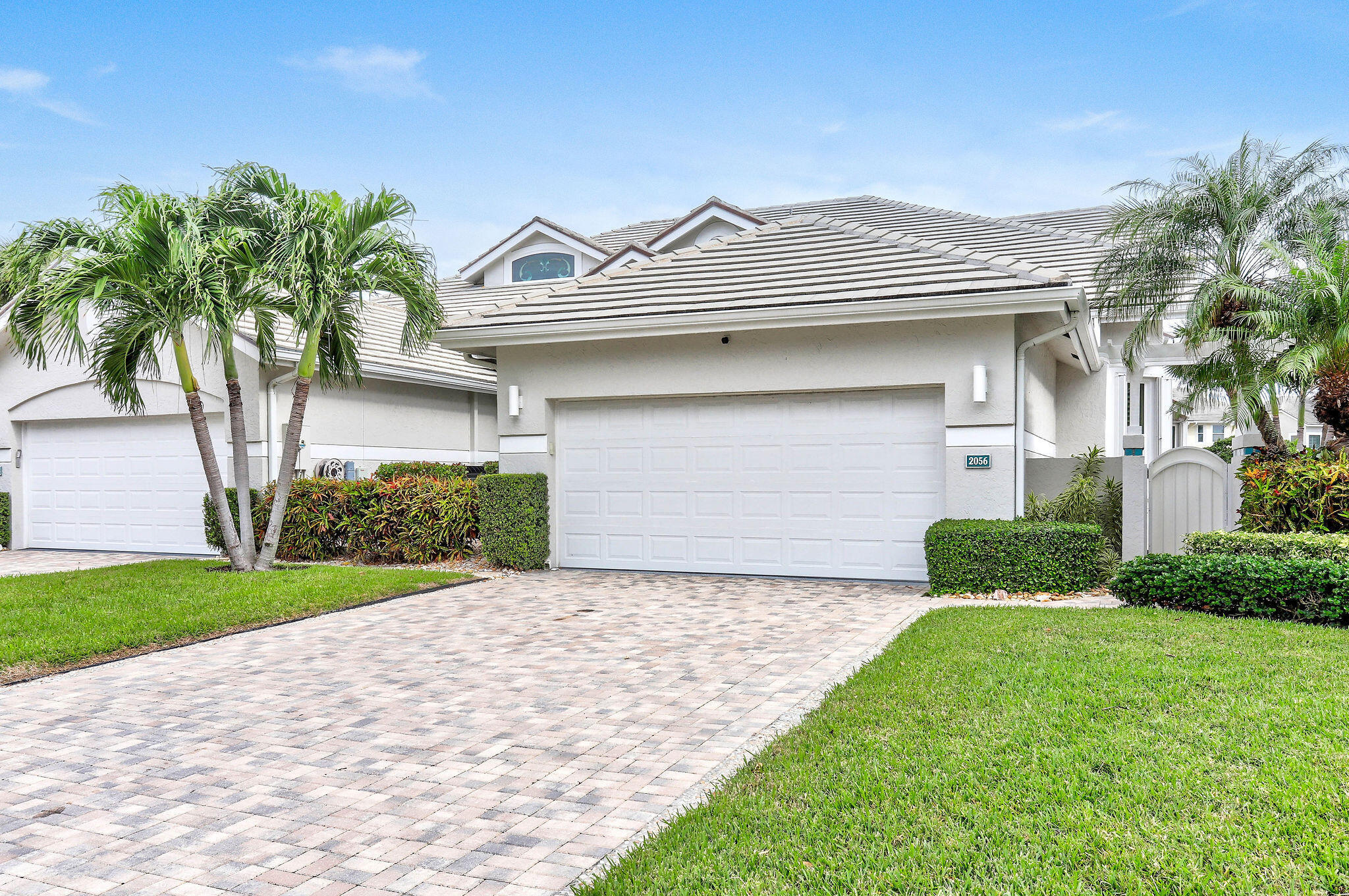 2056 Windward Way Jupiter, FL 33477 - Photo 46 of 58 a front view of a house with a garden and plants