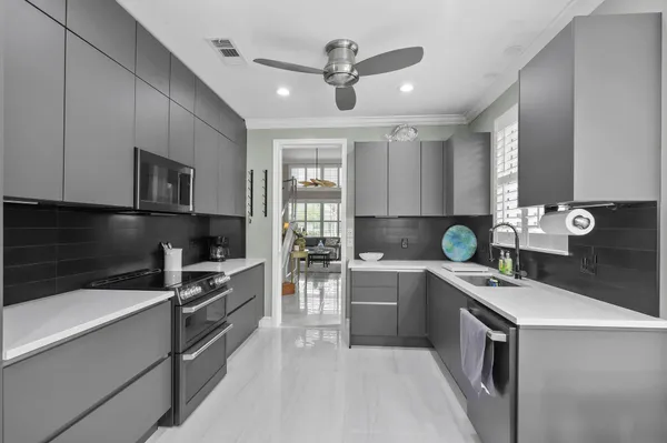 a kitchen with stainless steel appliances kitchen island granite countertop a sink a stove and a refrigerator
