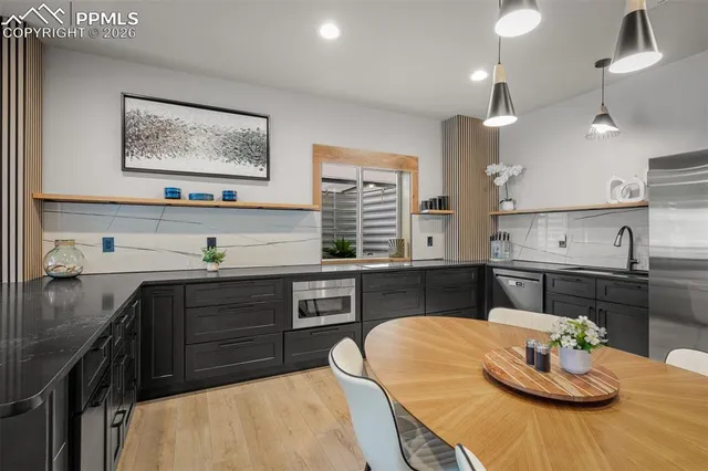 a kitchen with a sink stove and wooden floor