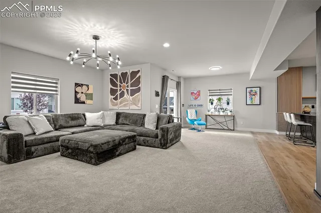 a living room with furniture chandelier and a flat screen tv
