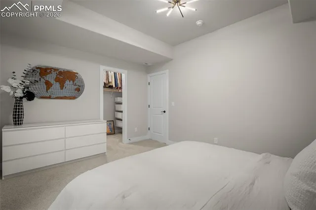 a bedroom with a bed and a white cabinet