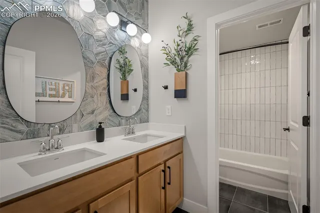 a bathroom with a double vanity sink and a mirror