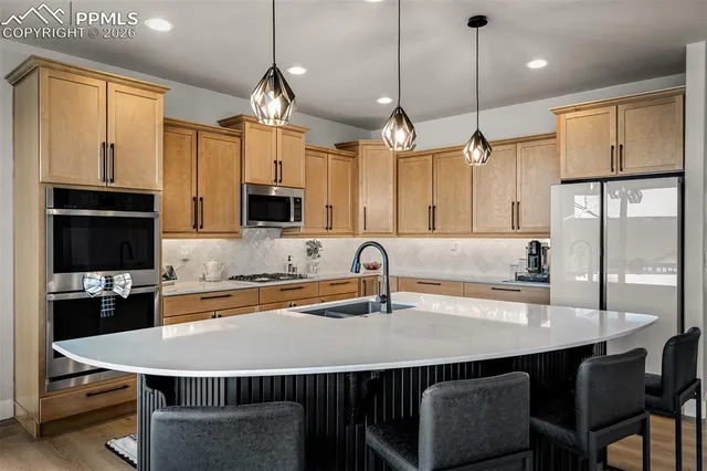 a kitchen with kitchen island a counter space a sink appliances and cabinets