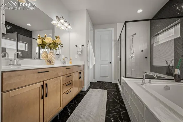 a spacious bathroom with a double vanity sink a large mirror a shower and a bathtub