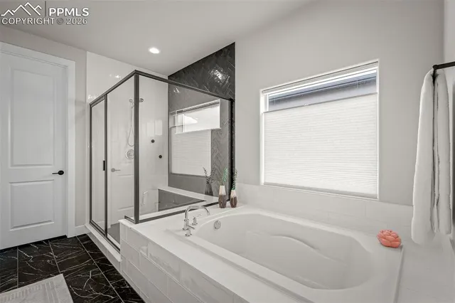 a bathroom with a tub shower and sink