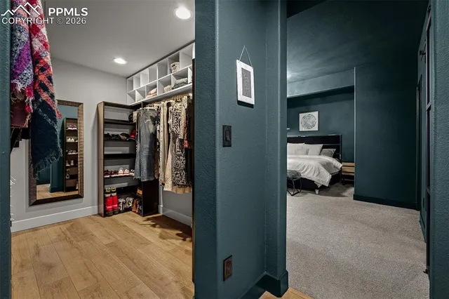 a view of walk in closet with clothes and shoes