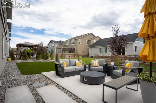 a view of a patio with couches and a potted plant on the side of a road