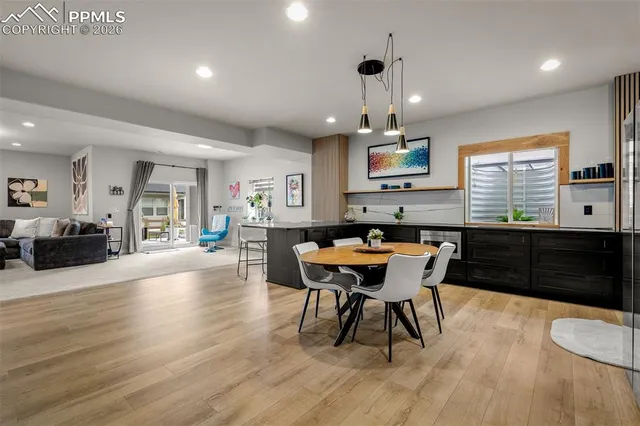 a kitchen with stainless steel appliances a dining table chairs and wooden floor