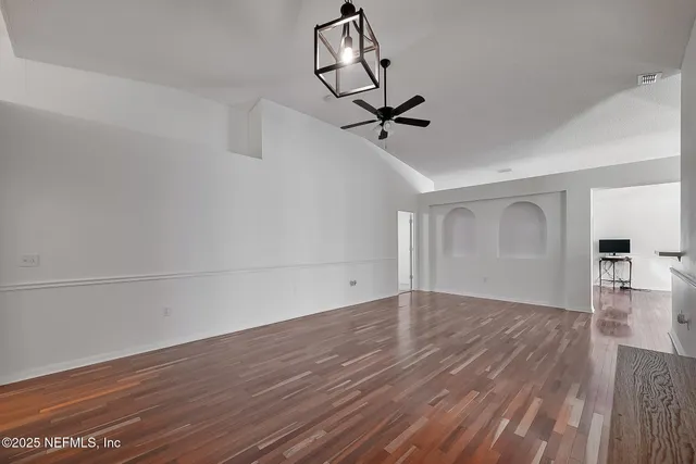 a view of empty room with wooden floor and window
