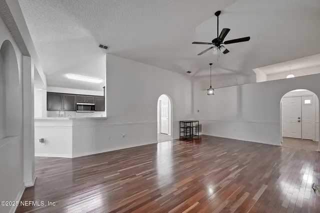 a view of empty room with wooden floor and window