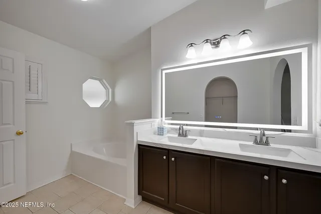 a bathroom with a granite countertop sink mirror and bathtub