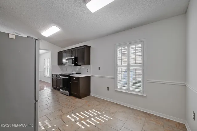 a kitchen with stainless steel appliances kitchen island granite countertop a refrigerator and a stove top oven