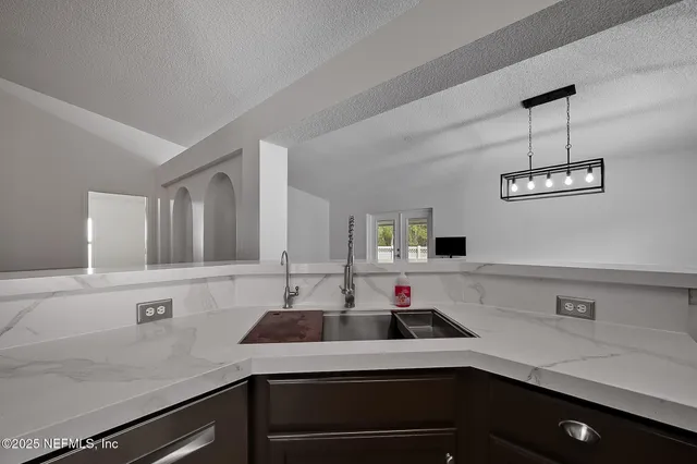 a view of a kitchen with a sink and wooden floor