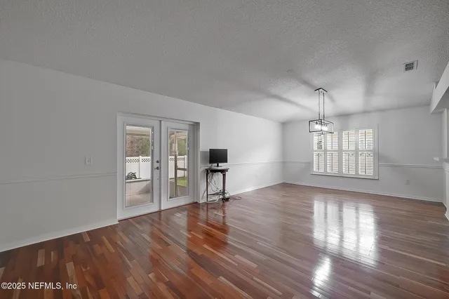 a view of empty room with wooden floor and window