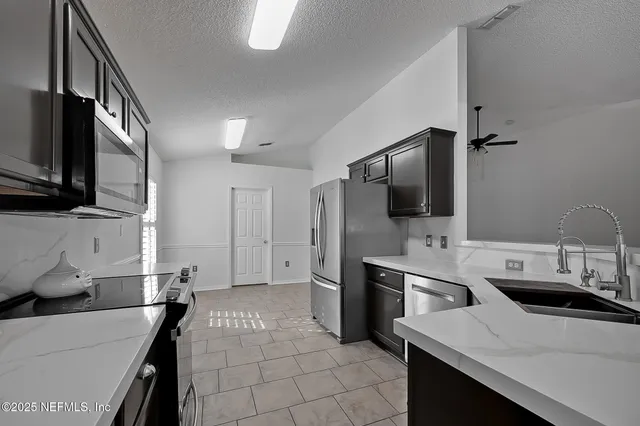 a kitchen with a sink appliances and cabinets