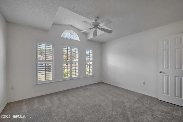 an empty room with a ceiling fan and bathroom