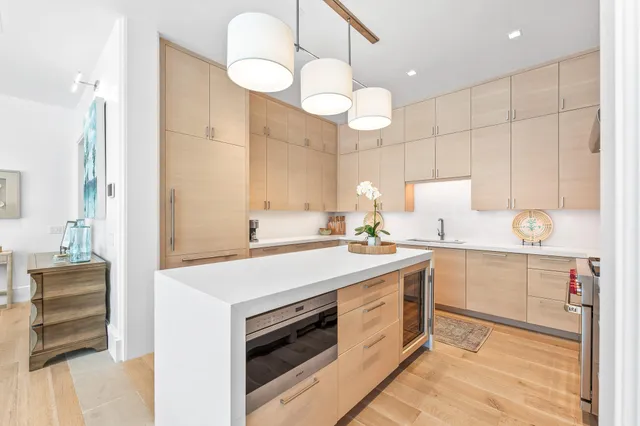 a kitchen with stainless steel appliances a stove a sink and a white cabinets