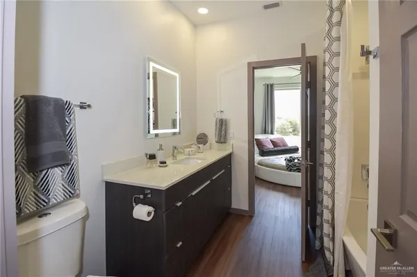a en suite bathroom with a granite countertop sink and a mirror