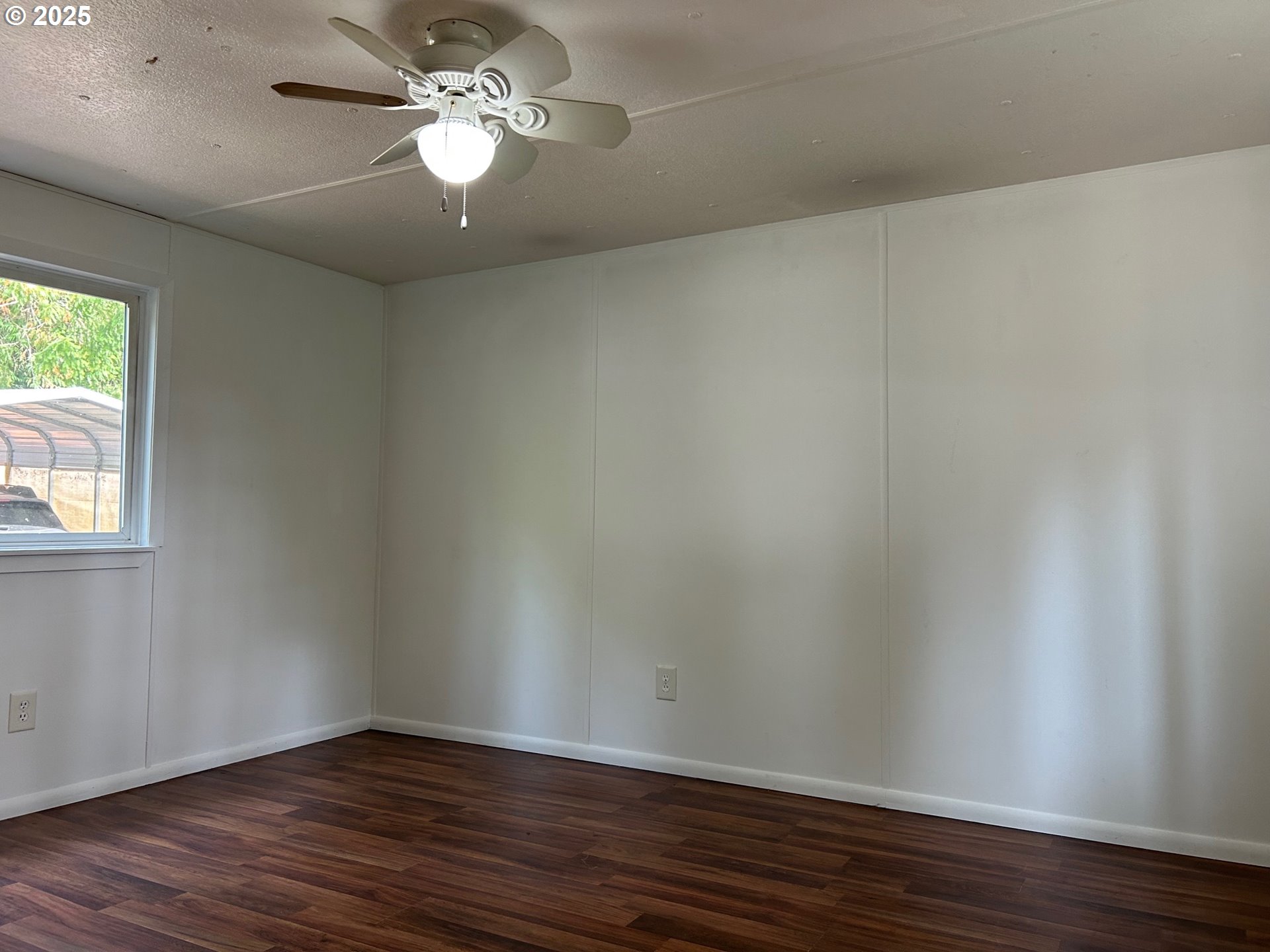 89510 Highway 101, Unit 26 Florence, OR 97439 - Photo 6 of 16 a view of an empty room with wooden floor and a window