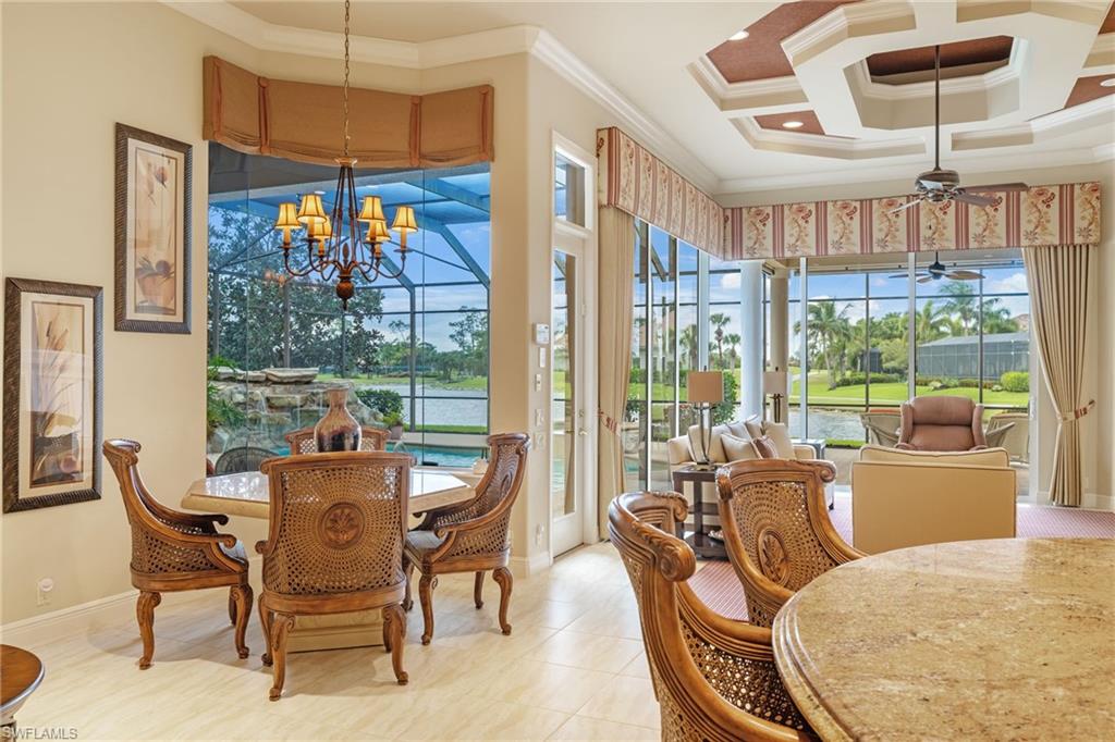 7511 Hogan Court Naples, FL 34113 - Photo 12 of 50 a dining room with furniture a chandelier and wooden floor