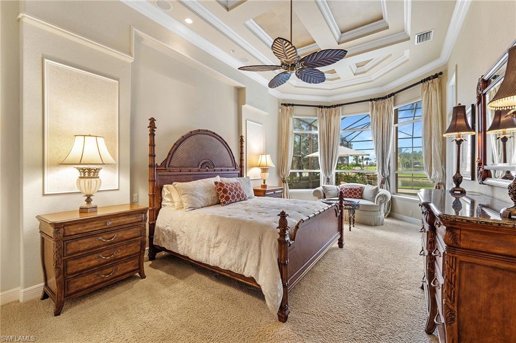 7511 Hogan Court Naples, FL 34113 - Photo 23 of 50 a bedroom with a bed a ceiling fan and a large dresser