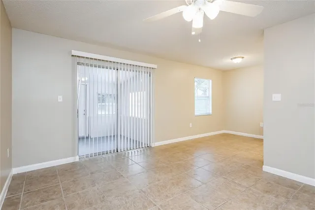 en empty room with windows and ceiling fan