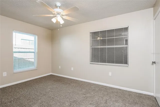 an empty room with a window and a fan