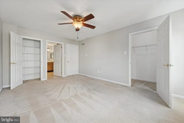 an empty room with closet and ceiling fan