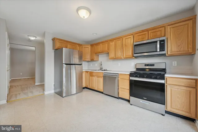 a kitchen with stainless steel appliances granite countertop a stove a sink and a refrigerator with cabinets