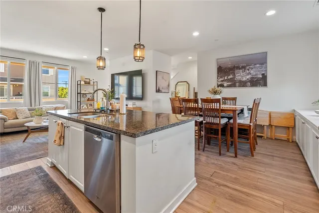a kitchen with stainless steel appliances granite countertop refrigerator cabinets dining table and chairs