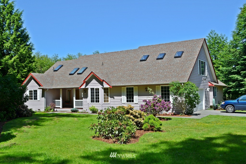 2469 Goss Ridge Road Freeland, WA 98249 - Photo 2 of 25 a front view of a house with a garden and plants