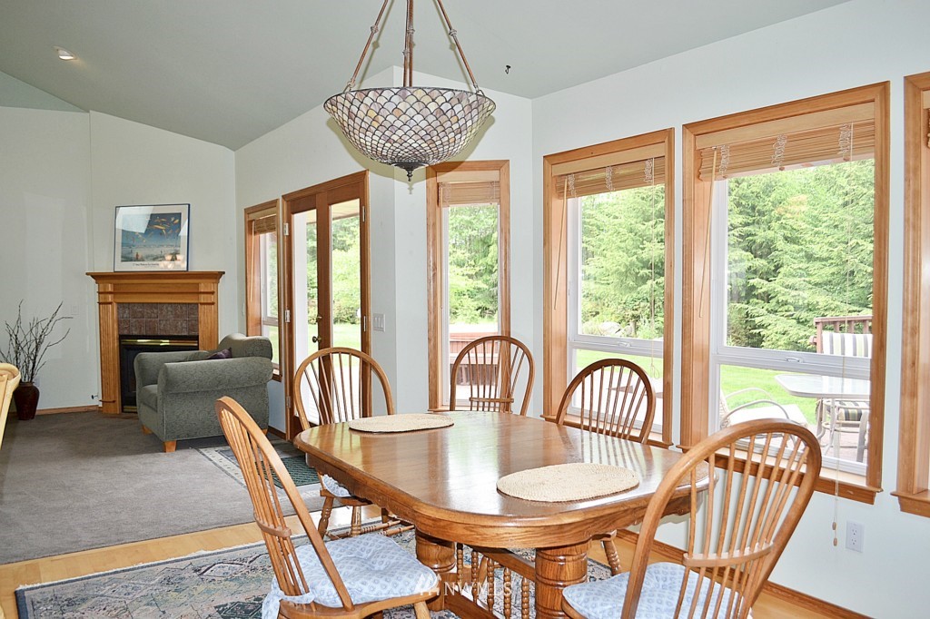 2469 Goss Ridge Road Freeland, WA 98249 - Photo 8 of 25 a dining room with furniture a chandelier and wooden floor